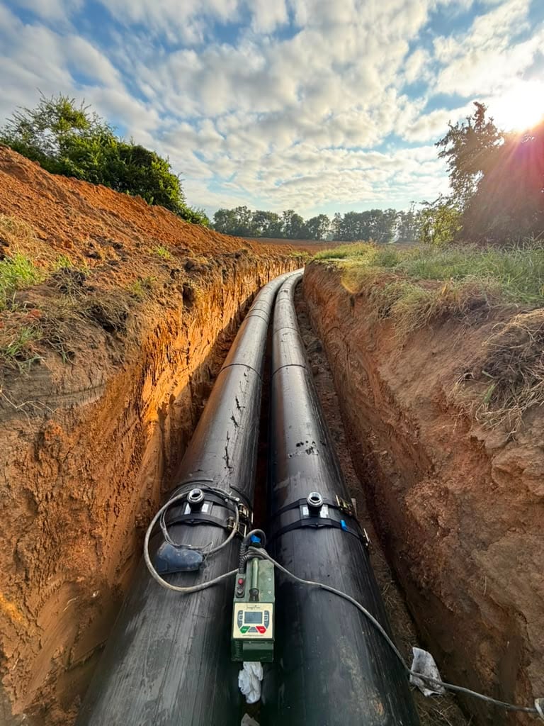 Two HDPE pipe runs with couplings in a narrow trench