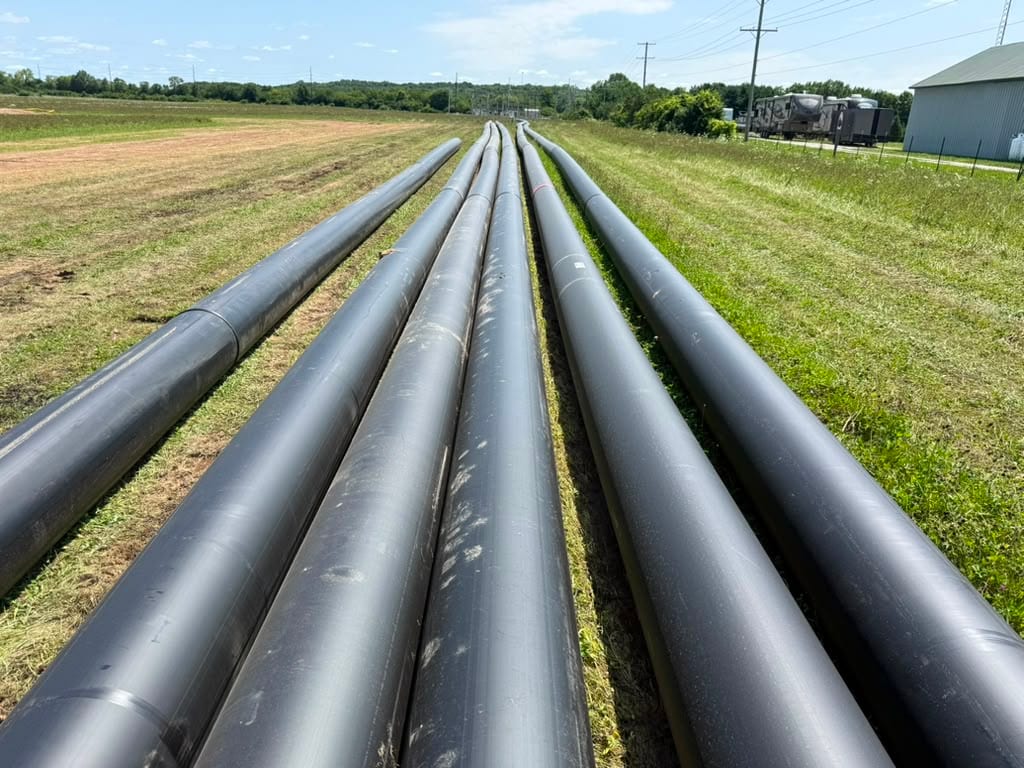 Three strings of fused HDPE pipe staged along a right-of-way