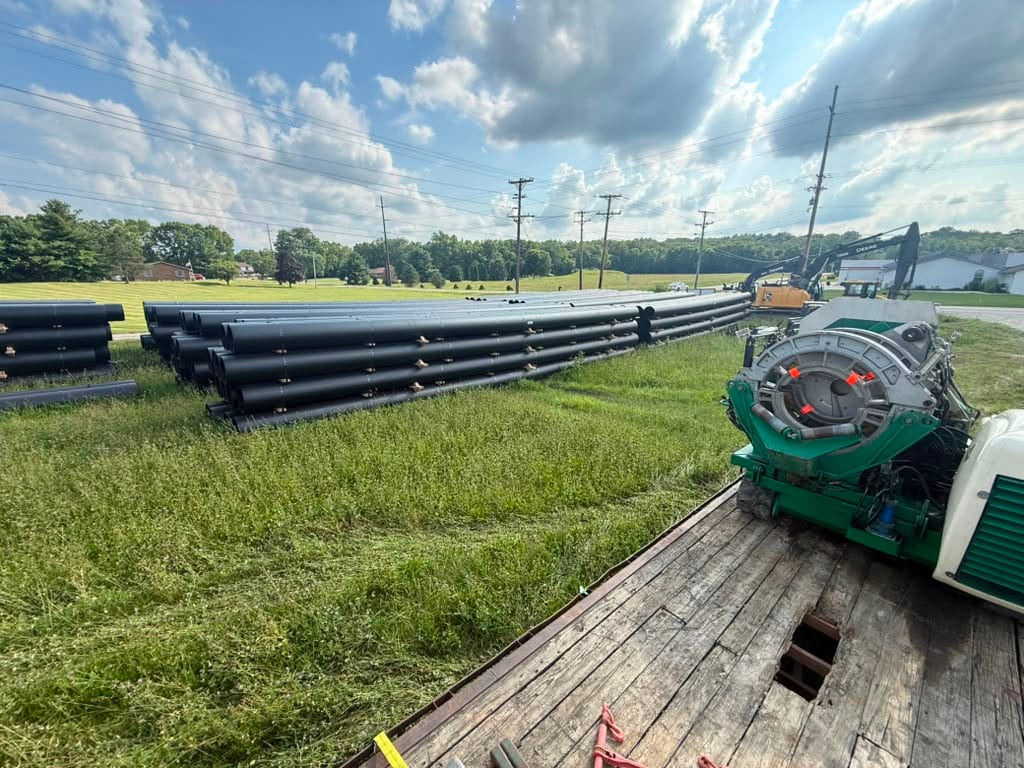 Stacks of HDPE pipe beside a fusion machine