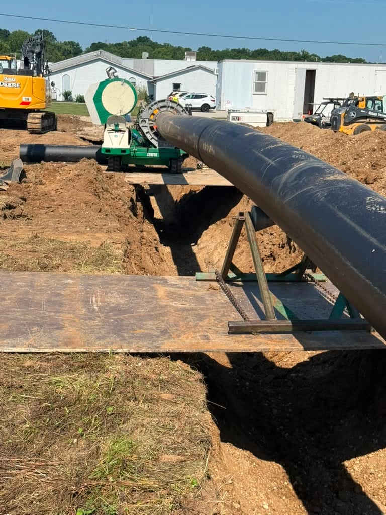 HDPE pipe run being lowered into a trench